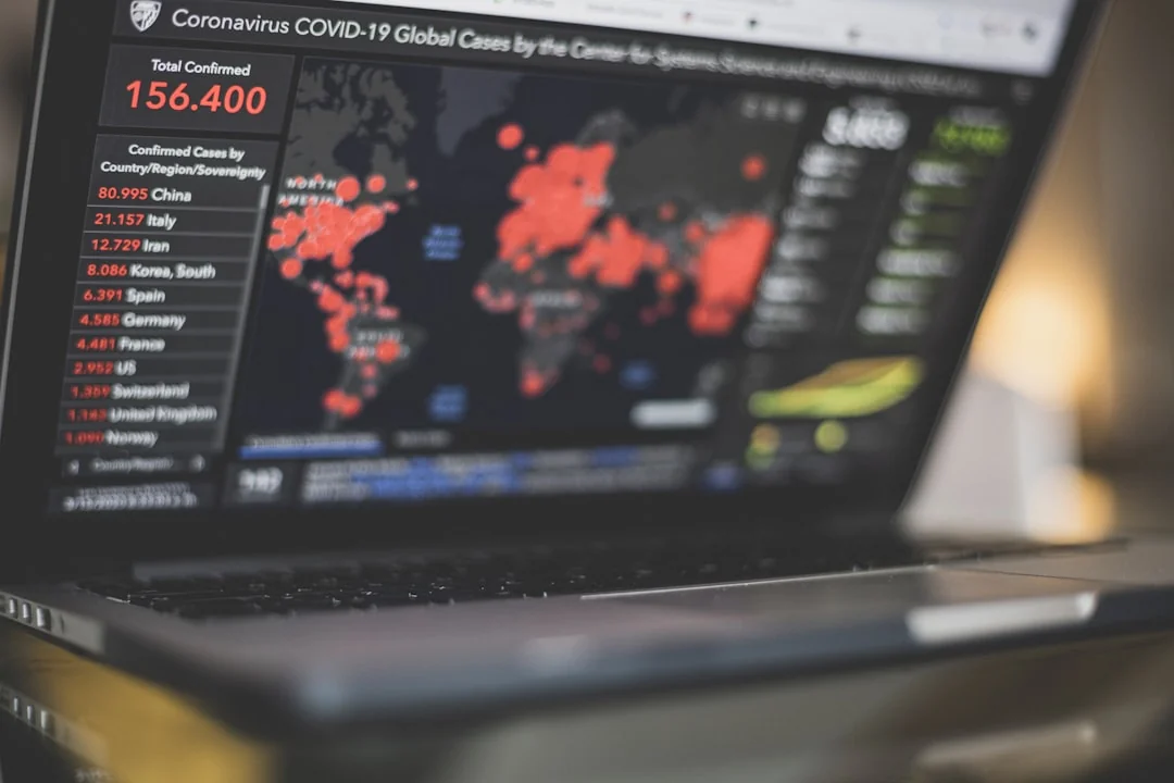 Person checking stock market graphs on laptop and smartphone, focusing on financial data.