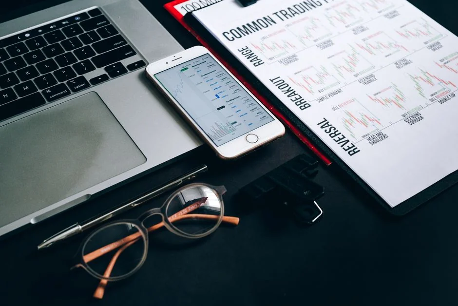 Overhead view of e-commerce chart with smartphone calculator and magnifying glass on a table.